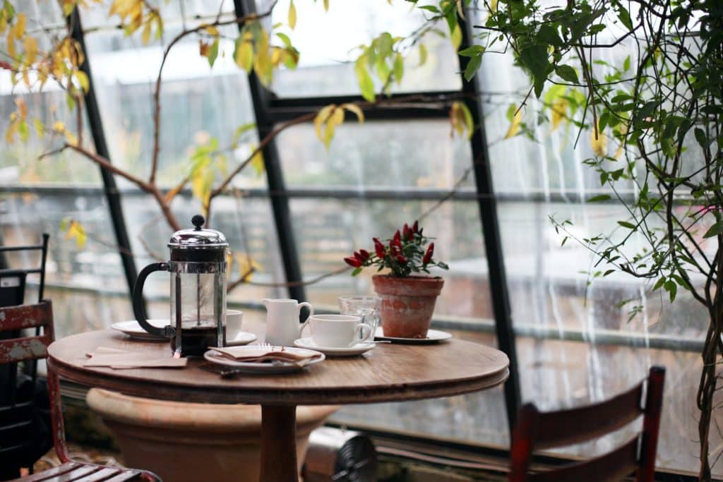 mesa cafetería con tazas de café y platos vacíos